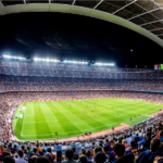 Wide view of a packed football stadium under floodlights during a match