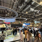 Visitors exploring vehicle displays at an international automotive exhibition.