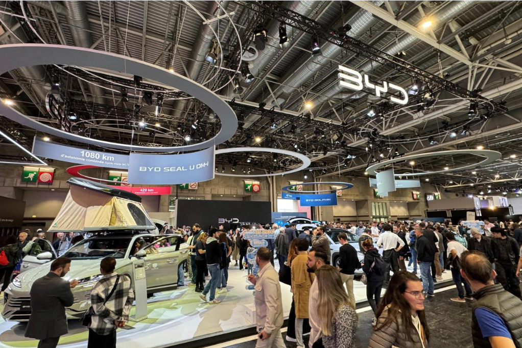 Visitors exploring vehicle displays at an international automotive exhibition.