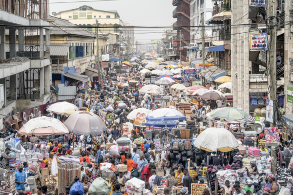 Shoppers and traders at a busy urban marketplace in Africa.