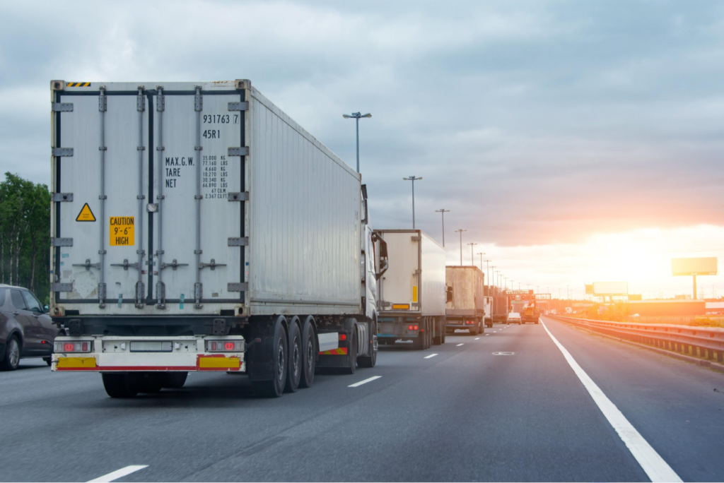 Heavy freight trucks transporting goods along a highway.