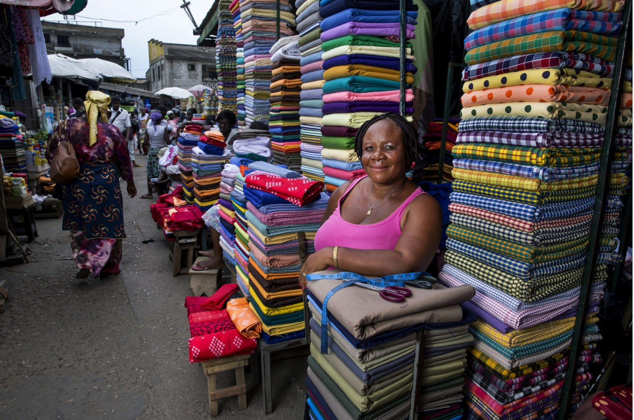 Traders and small business owners operating in a busy African commercial market.