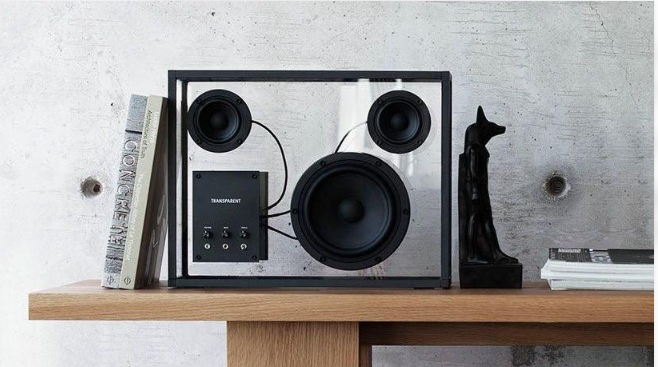 Physical Transparent speaker featuring a glass enclosure, visible speaker drivers and aluminium framing.