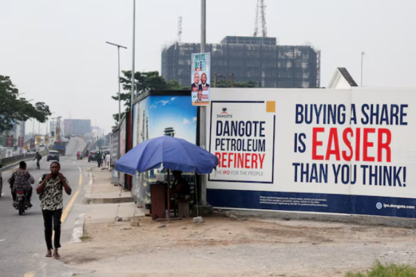 Street advertisement promoting the Dangote Petroleum Refinery IPO in Nigeria, with the message “Buying a share is easier than you think.”