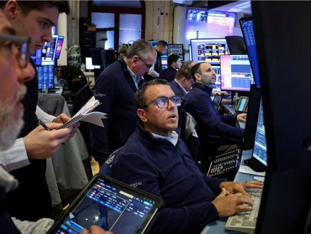 Traders monitoring financial markets on computer screens at a stock exchange.