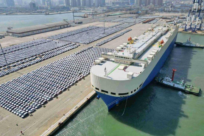 Rows of finished vehicles at an international automobile shipping terminal.