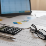 Calculator and financial paperwork arranged on an office desk