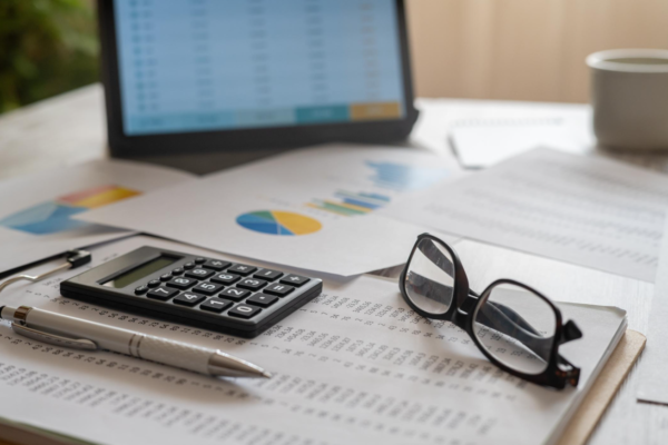 Calculator and financial paperwork arranged on an office desk