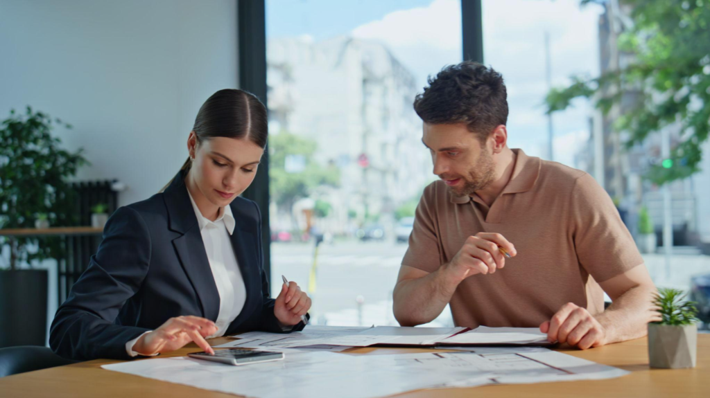 Two business professionals reviewing documents together at a meeting table