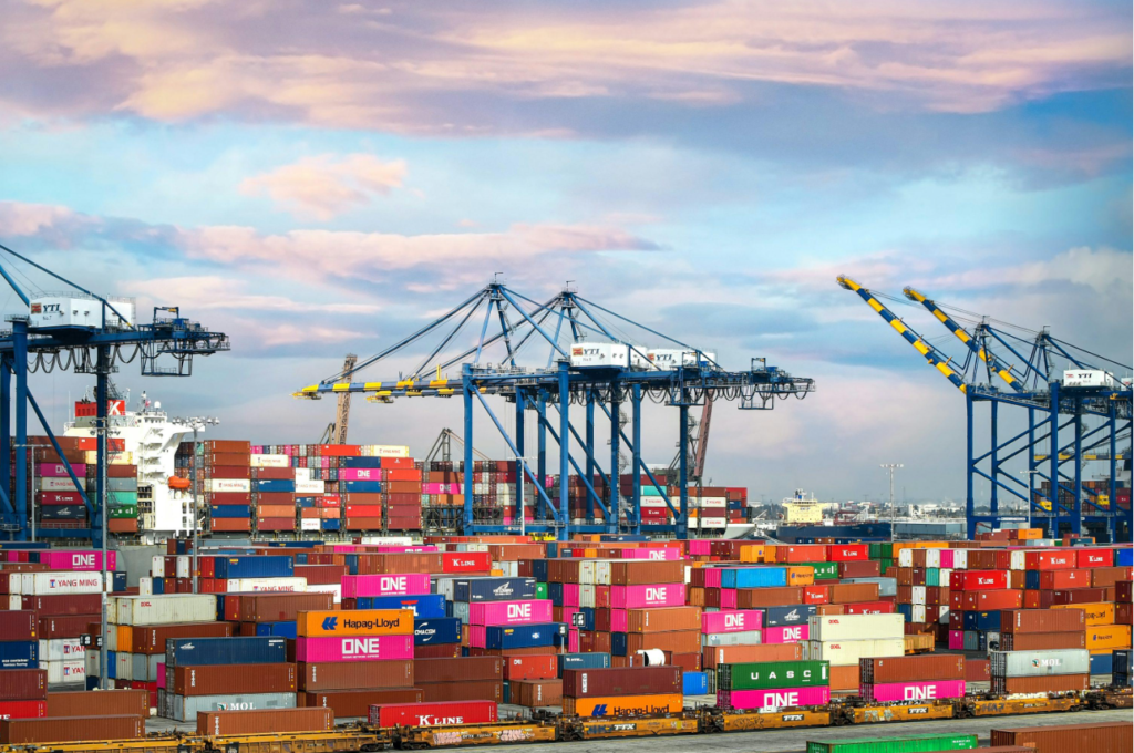 Cargo containers and industrial cranes at a busy international shipping port