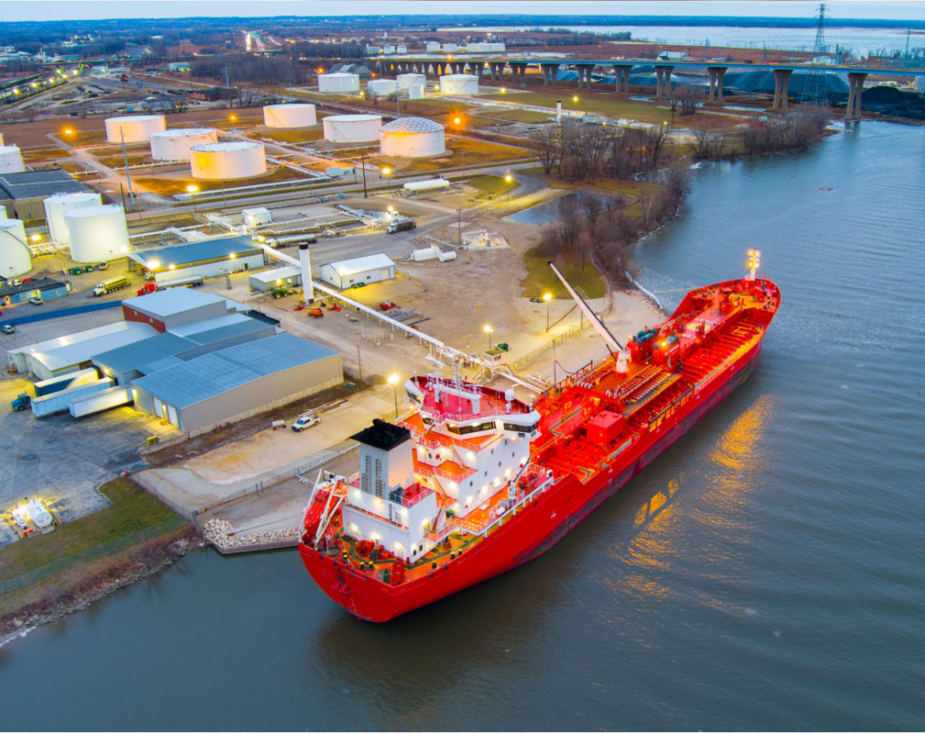 Red tanker docked beside industrial facilities on the waterfront in Port Credit, Ontario
