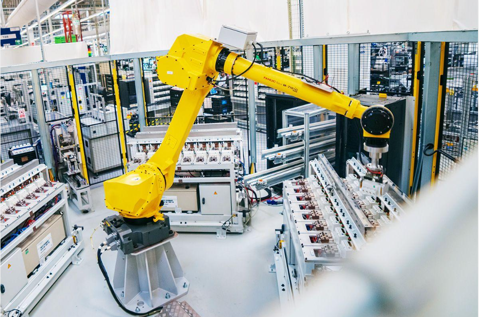 Yellow industrial robotic arm operating inside a modern manufacturing facility