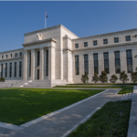 Federal Reserve building in Washington, D.C., with a lawn and walkway in front.